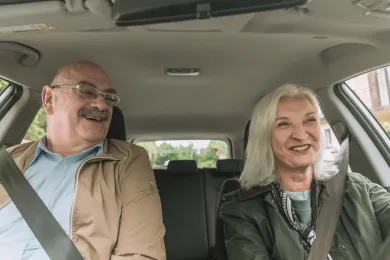 Eine Freiwillige des Rotkreuz-Fahrdienstes fährt einen Klienten zu einem Termin. 